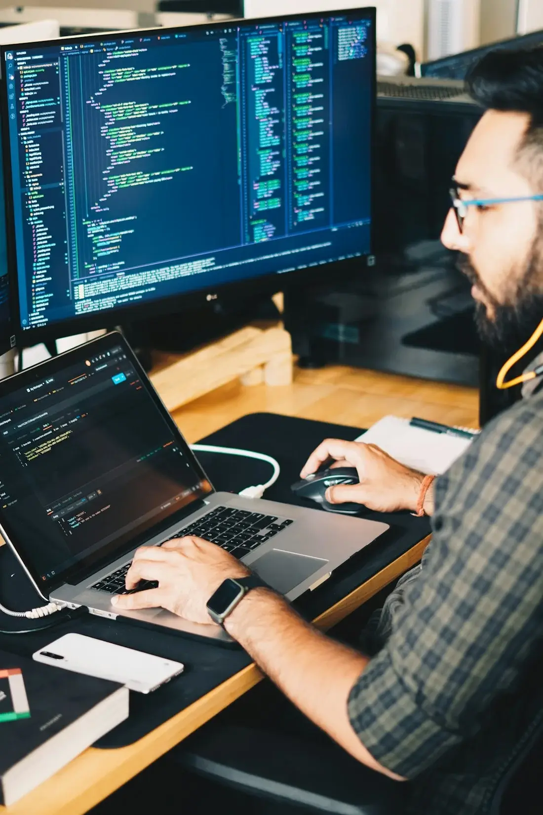 IT-konsult som programmerar vid två skärmar
